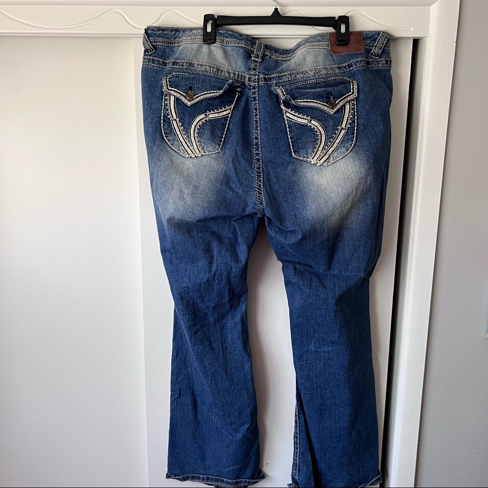 Stretch denim jeans with distress on legs and pocket embellishments